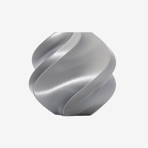 Silver Bambu Lab PLA Silk+ filament spool from Additronix, showcasing smooth, shiny 3D printing filament on a reel.