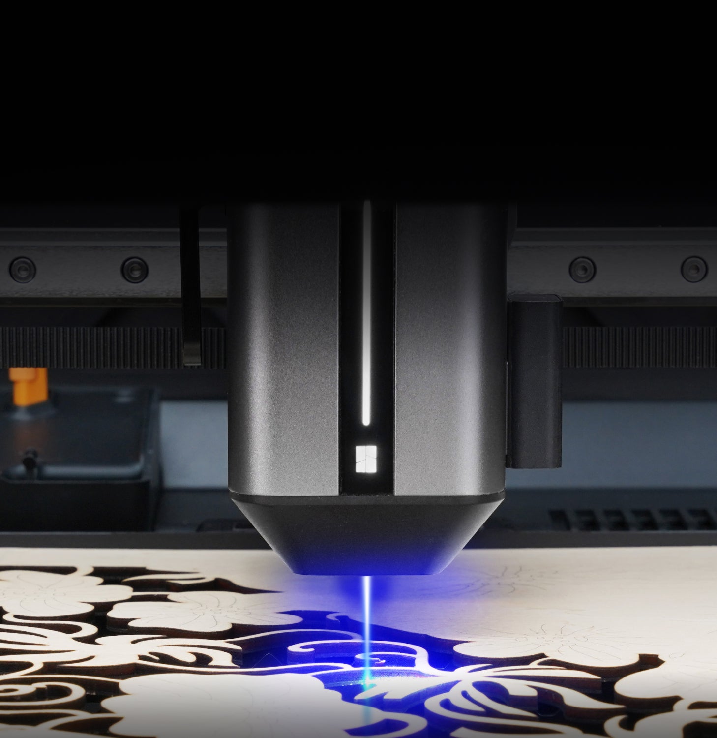 Laser engraving machine in action with a design on a surface