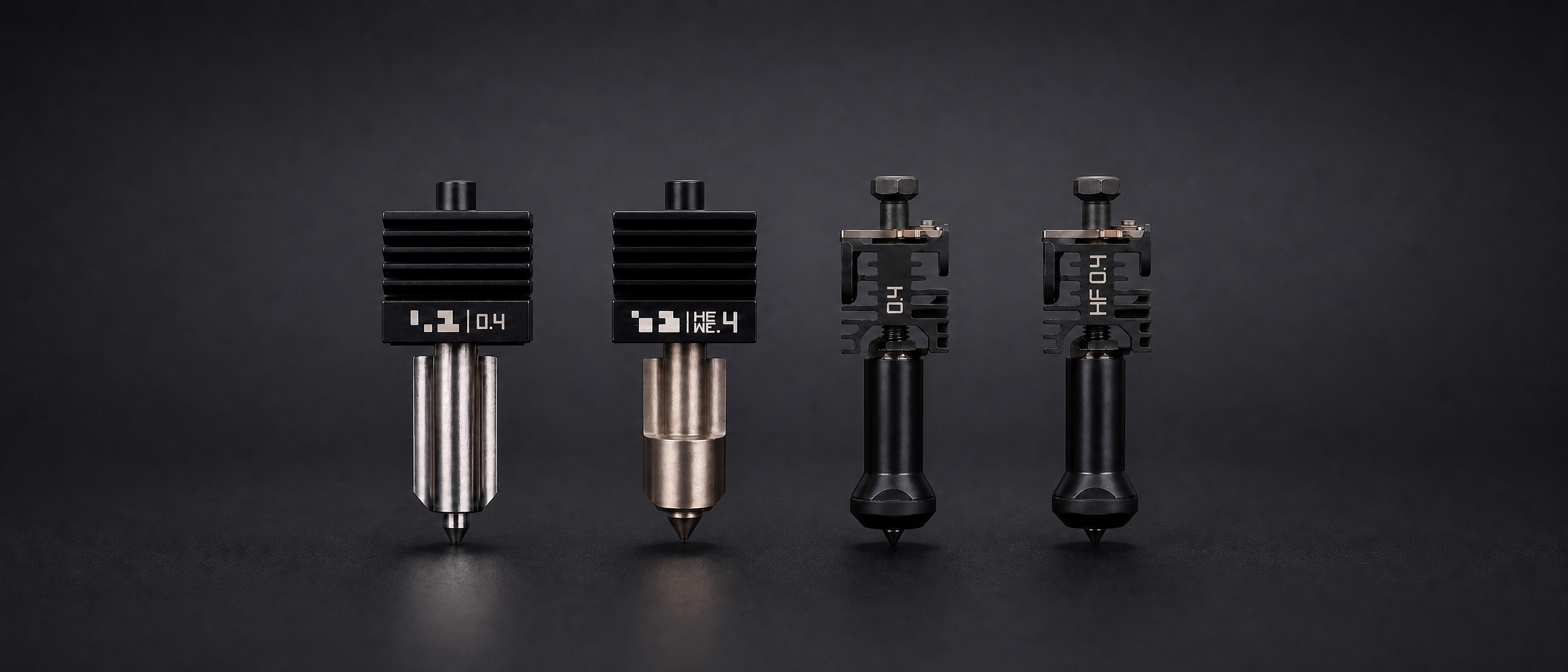 Four metallic nozzles on a dark background